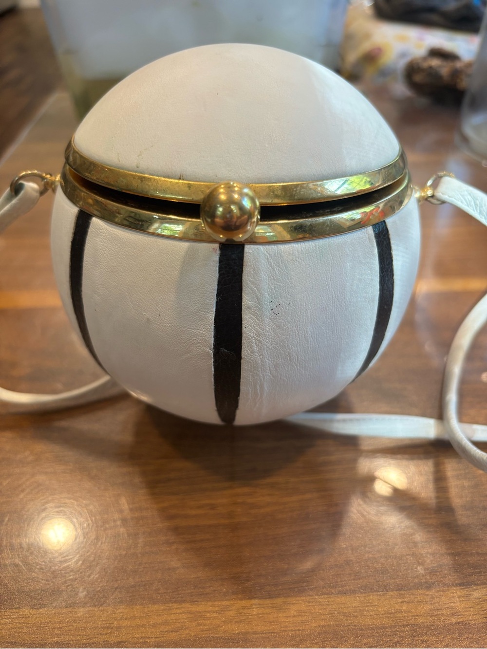 Round White Leather Crossbody Bag with Black Stripes and Gold Trim. ML designer